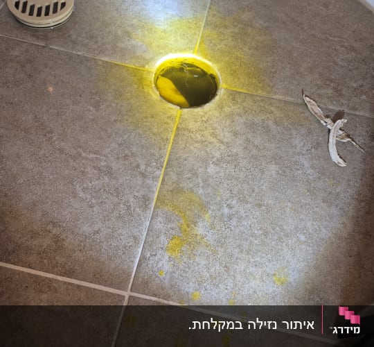 נזילה ברצפת חדר אמבטיה עם סימני מים